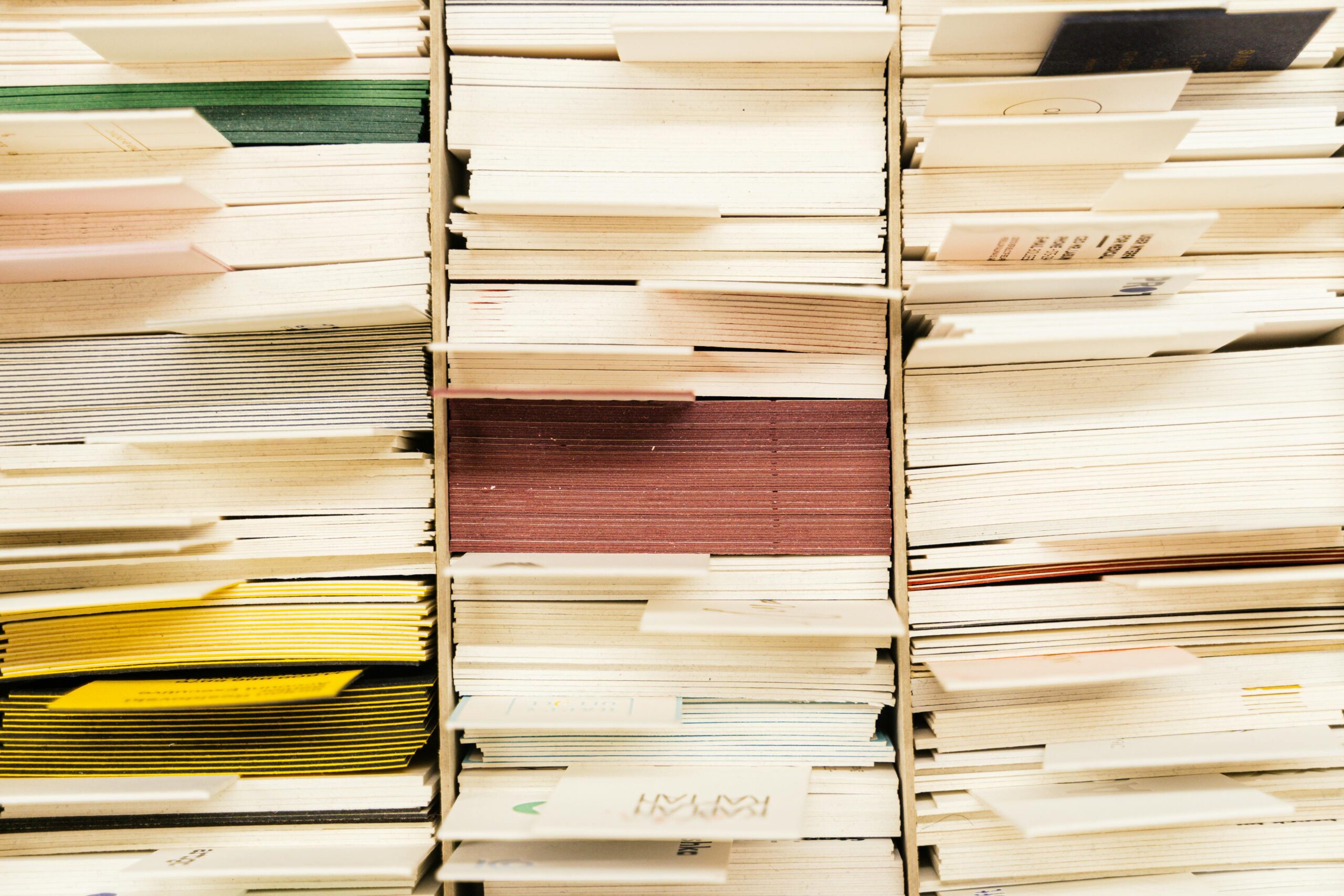 Stacks of paper documents and files arranged in office shelving